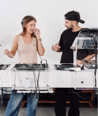 A woman is mastering how to use the DJS 1000 sampler in a hybrid DJ set.