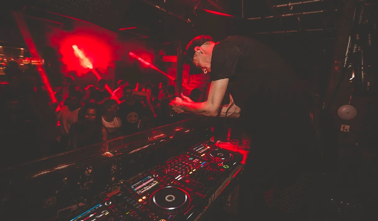 An interesting photo of a DJ bowing the crowd during a live DJ set