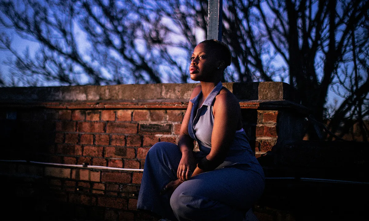 A low light and enigmatic DJ press photo of a woman in a park