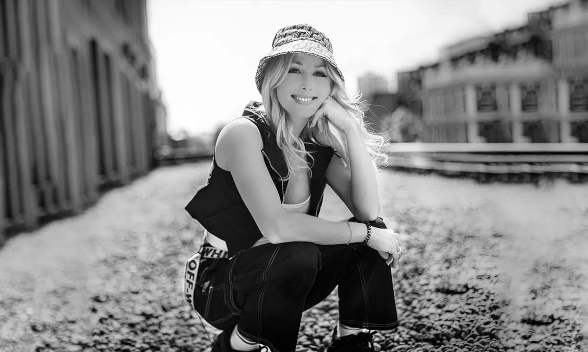 A funky DJ photo of a female DJ in a crouching pose