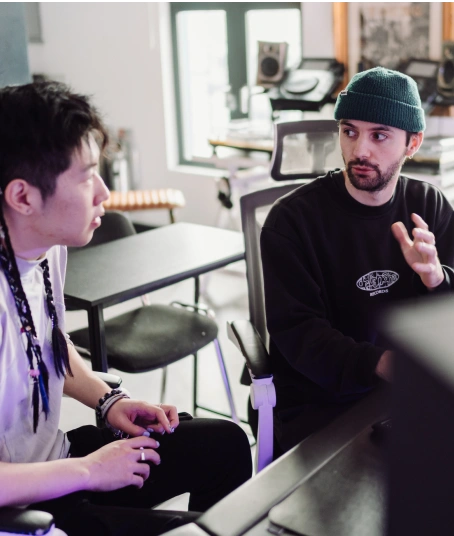 A production tutor guides his intermediate production course student on how to structure his track