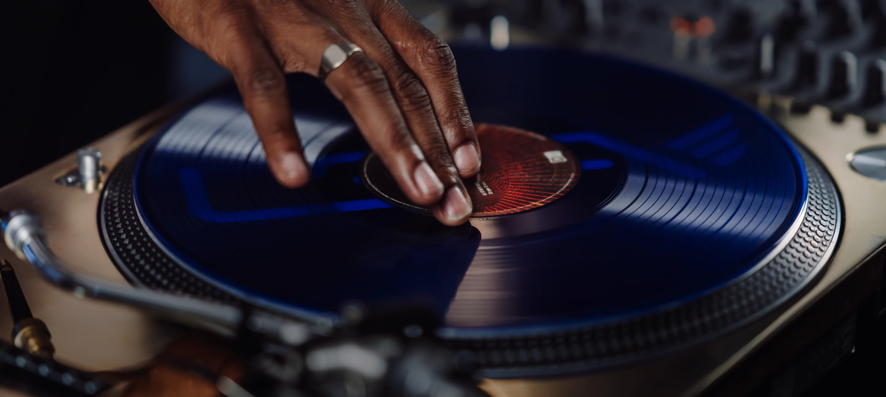 A hand cues a vinyl record ready for the perfect mix