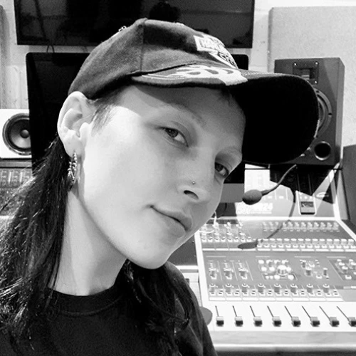 DJ and production tutor Claudia sitting in the recording studio in a professional press photo for London Sound Academy.