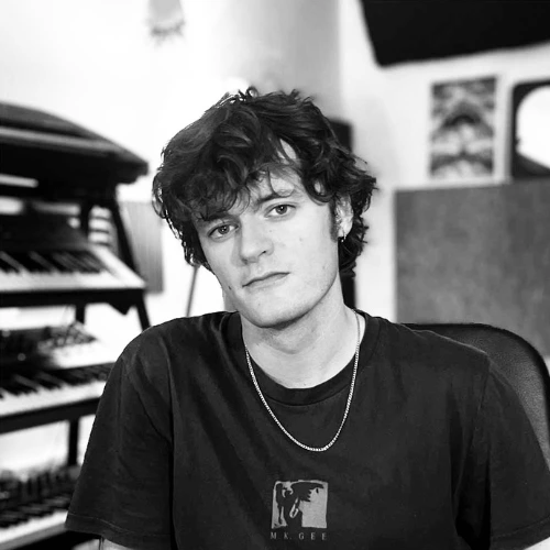 DJ and production tutor James sitting in the recording studio in a professional press photo for London Sound Academy.