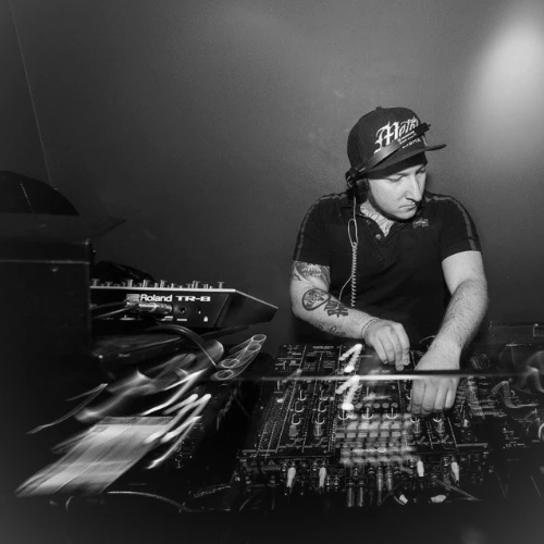 Senior DJ and music production tutor Olmo, in action DJing and smiling in a professional press photo for London Sound Academy.