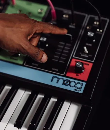 A mans hand uses a Moog synthesiser