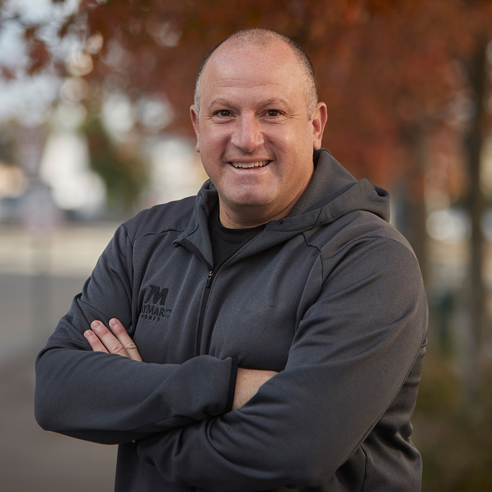 Headshot of Marc Rousso, founder of The Vision Academy. Smiling and wearing a JayMarc Homes hoodie.