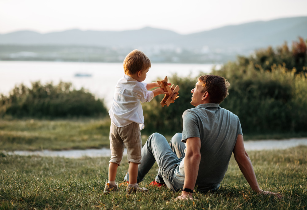Father spending time with young son outside in nature.