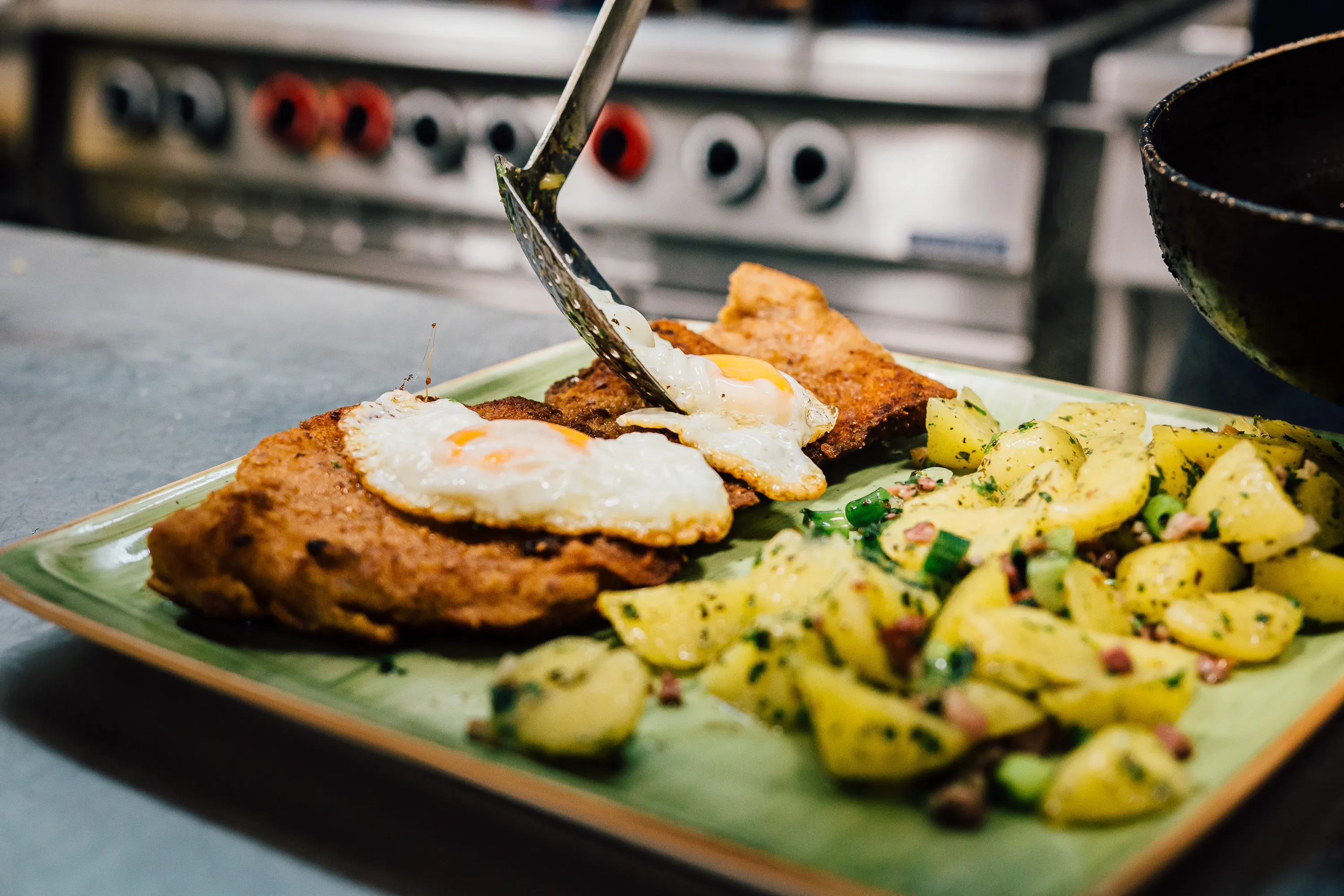 Serviertes Schnitzel mit Ei und Kartoffeln