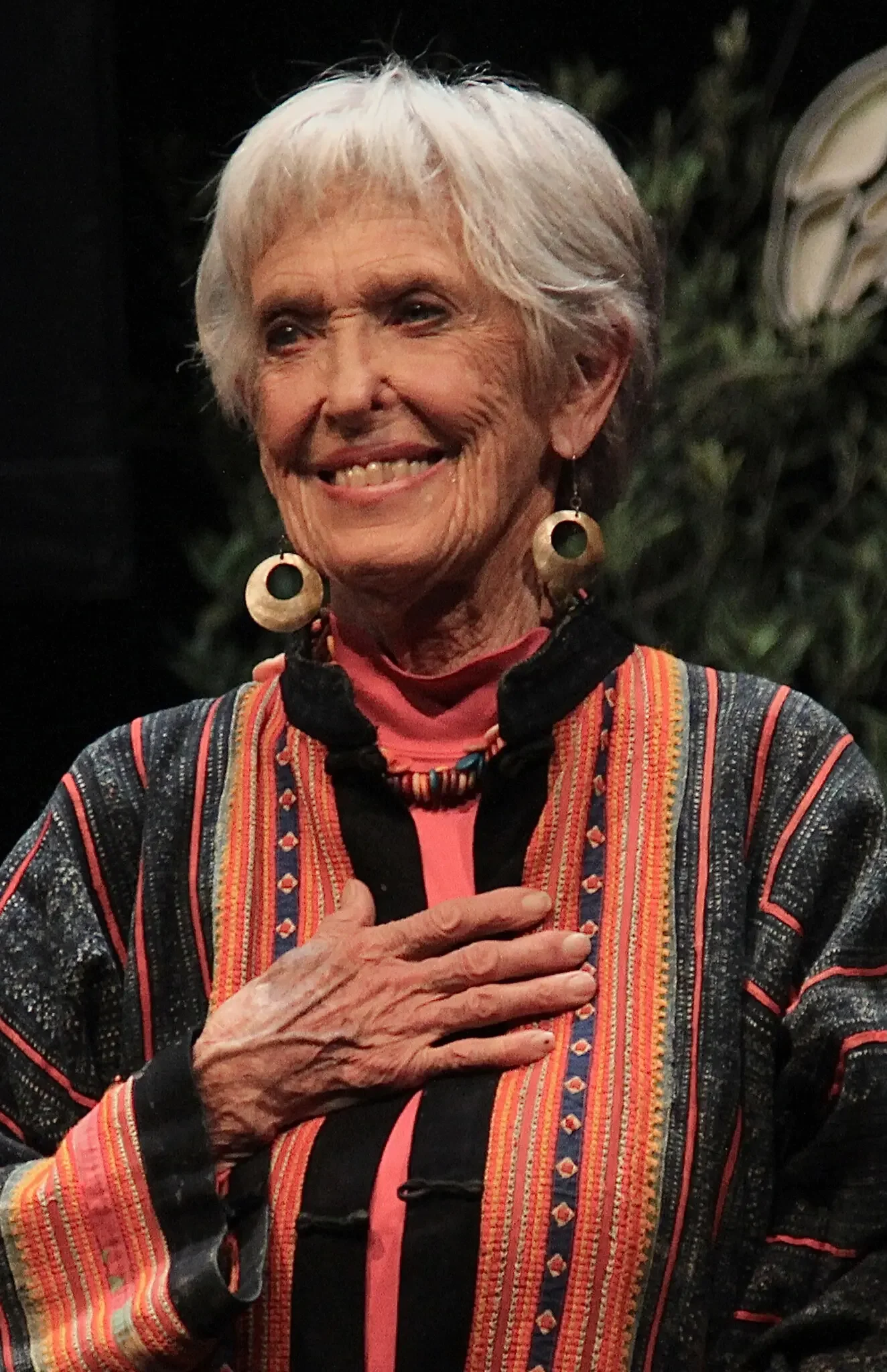 a photo of Joanna Macy with her hand over her chest