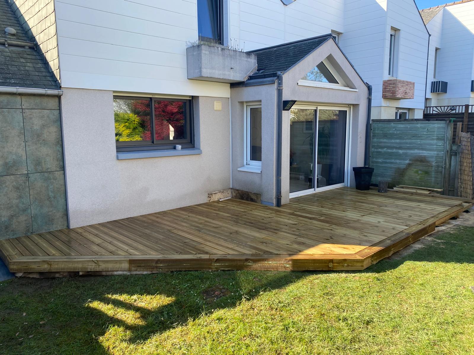 Jardin d'une maison avec une terrasse neuve en bois.