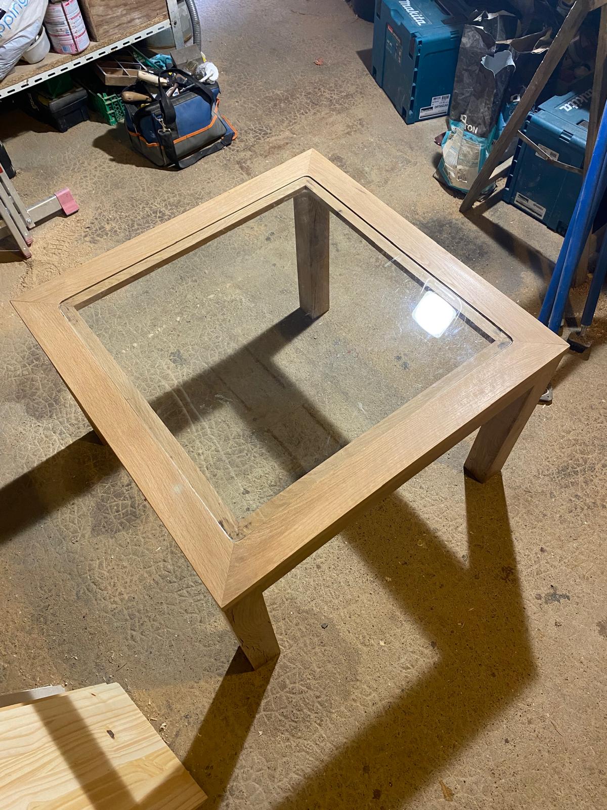 Table d'ébéniste en bois avec le centre de la table en verre.