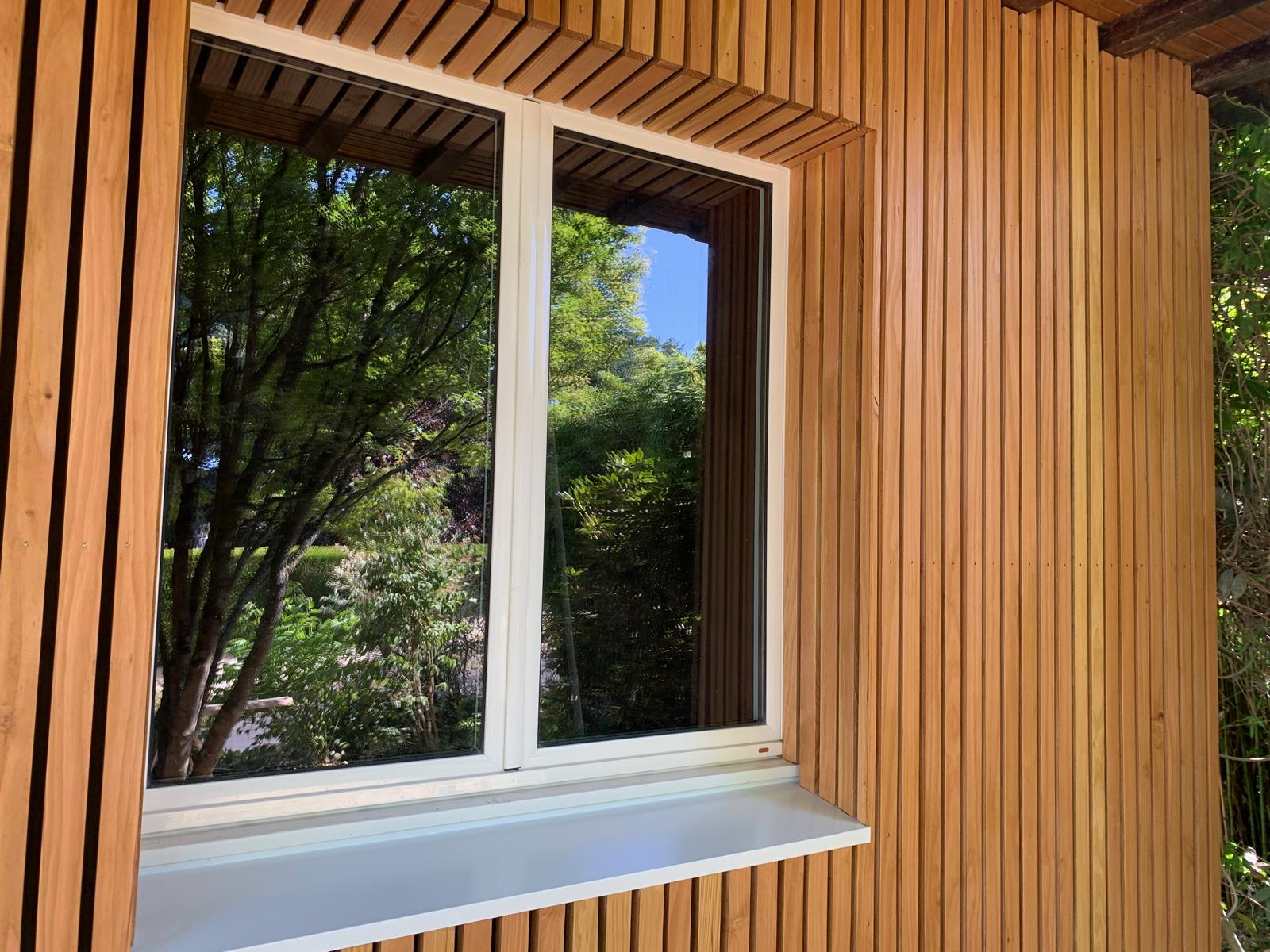 Fenêtre entourée d'un mur en planches de bois.
