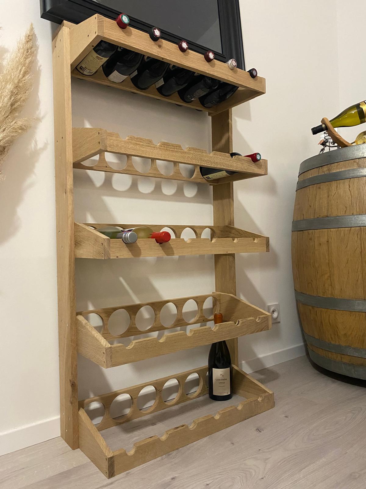 Range-bouteilles en bois posé contre un mur.