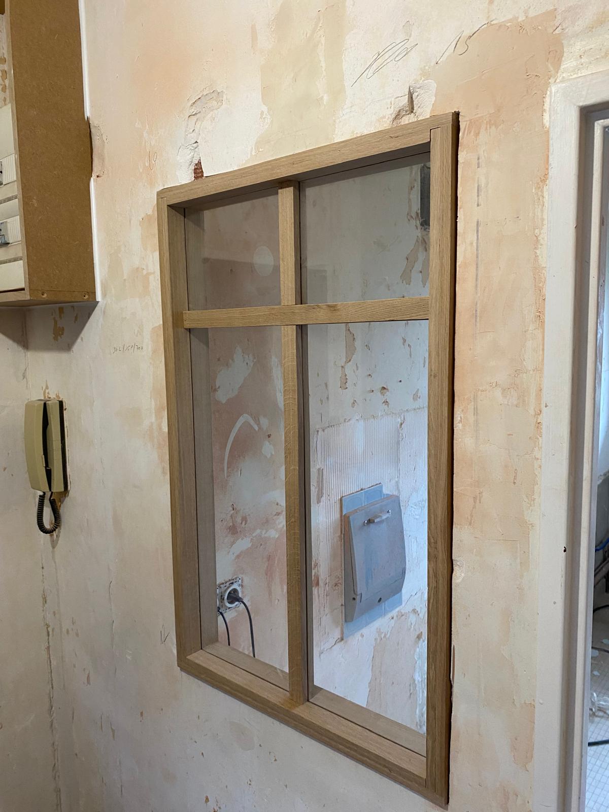 Verrière intérieure en bois en cours d’installation.