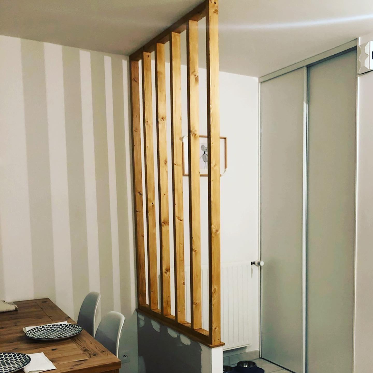 Claustra en bois séparant l’espace repas et l’entrée.