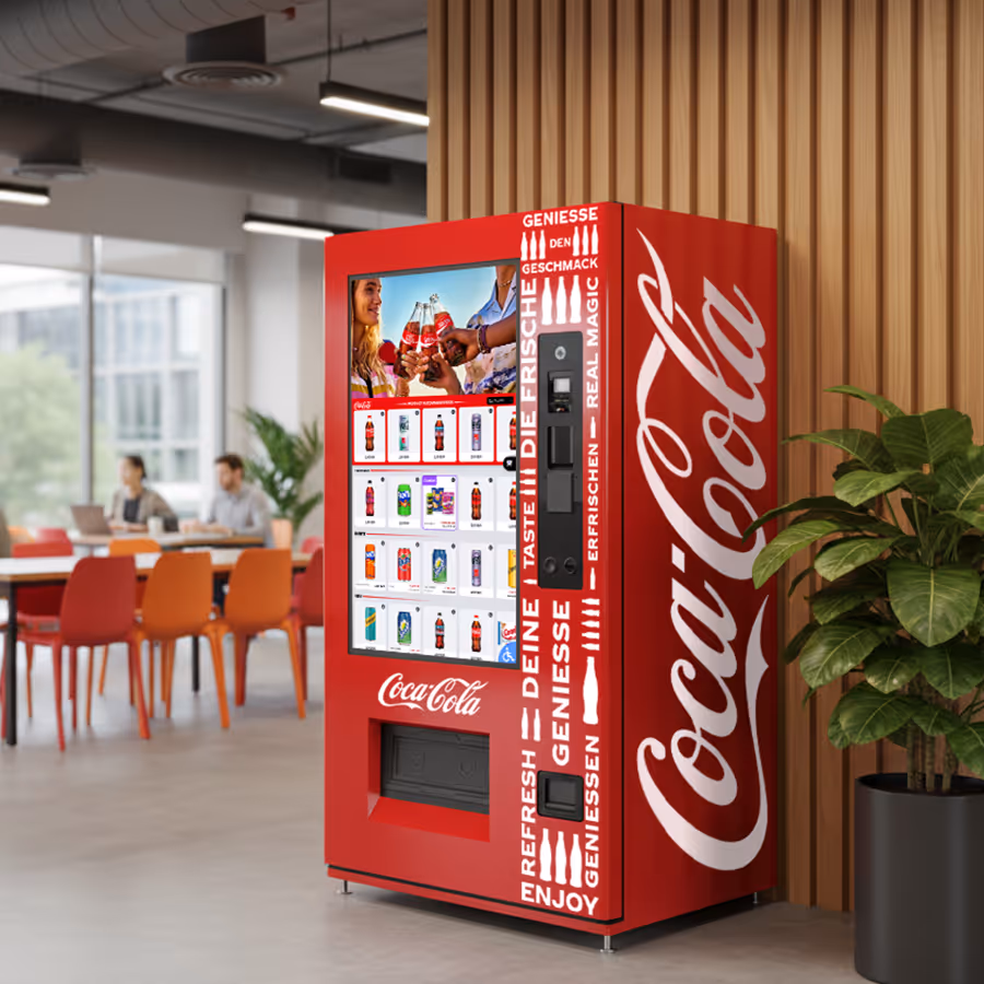 Red Coca-Cola vending machine with digital display and beverage selection in a modern office setting.
