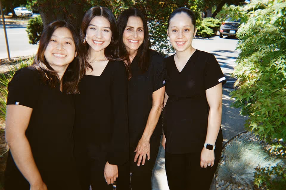 Dr. Alice Huang and staff posing for a photo in front of Concord Heritage Dental