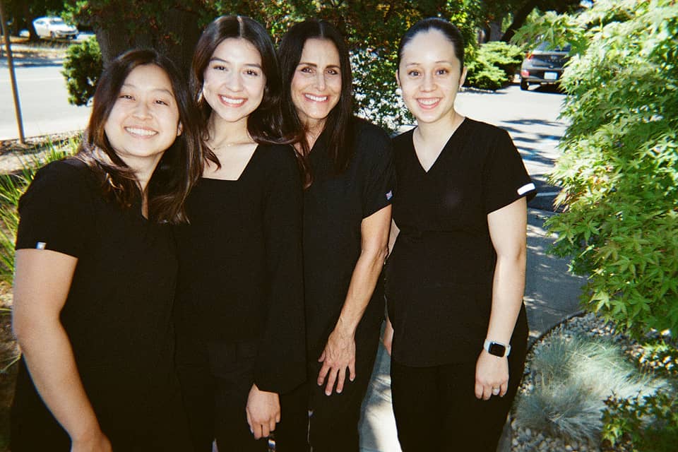 Dr. Alice Huang and staff posing for a photo in front of Concord Heritage Dental