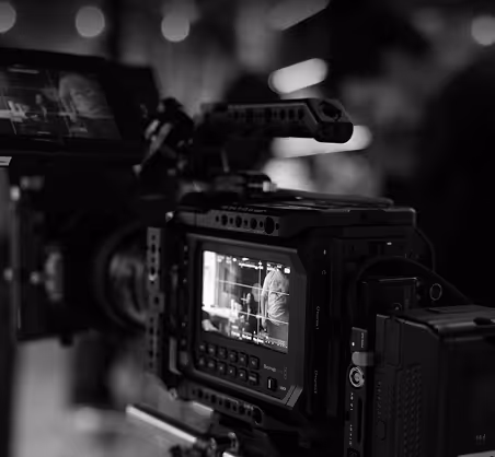 Caméra professionnelle en gros plan avec un écran montrant une scène filmée en noir et blanc.