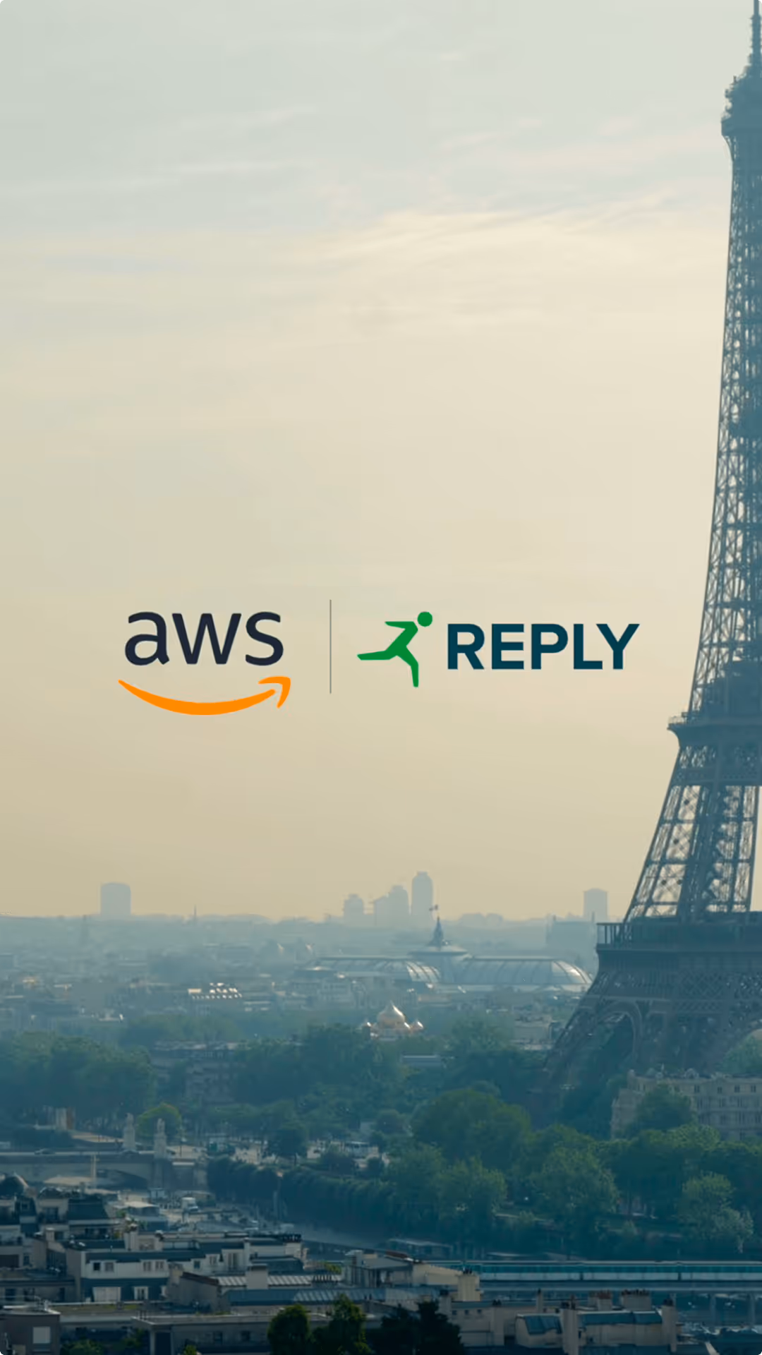 Logos AWS et Reply superposés sur une vue panoramique de la Tour Eiffel à Paris au coucher du soleil.