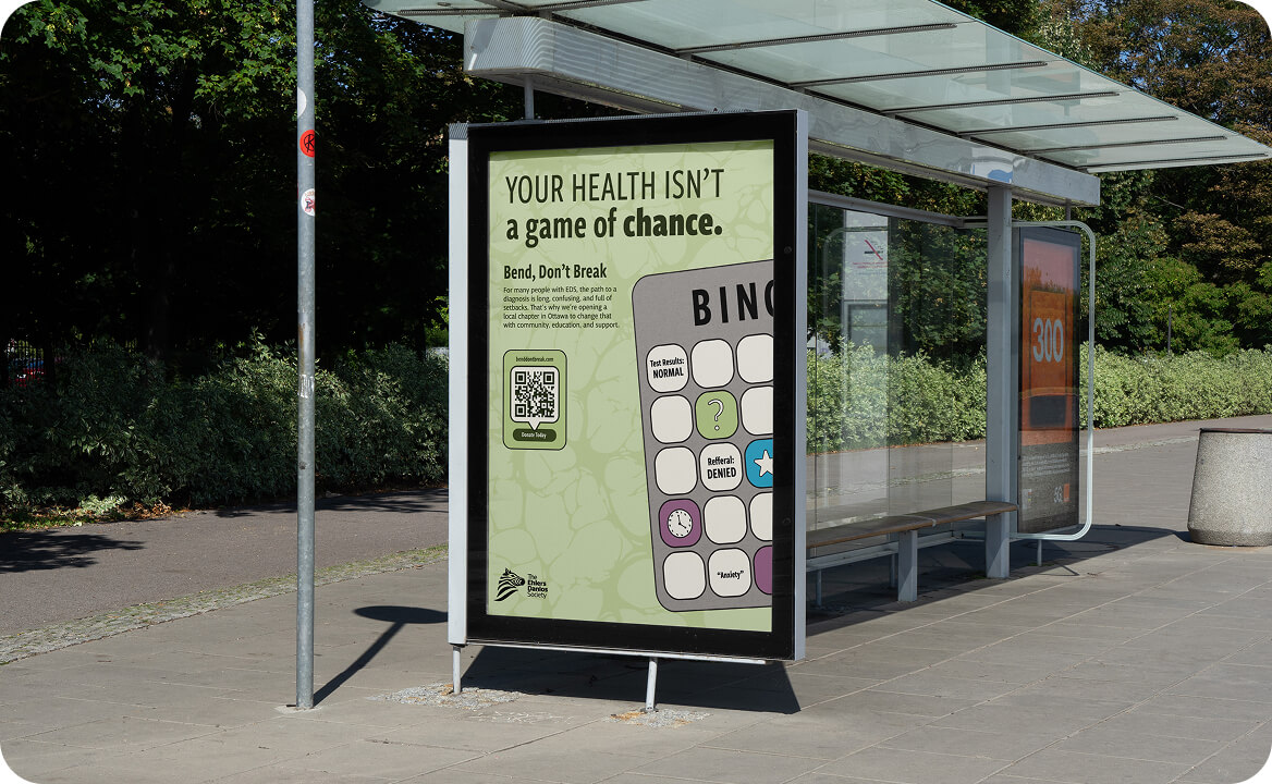 Bus shelter with a green poster that reads 'Your health isn't a game of chance' featuring a bingo card with health-related terms.