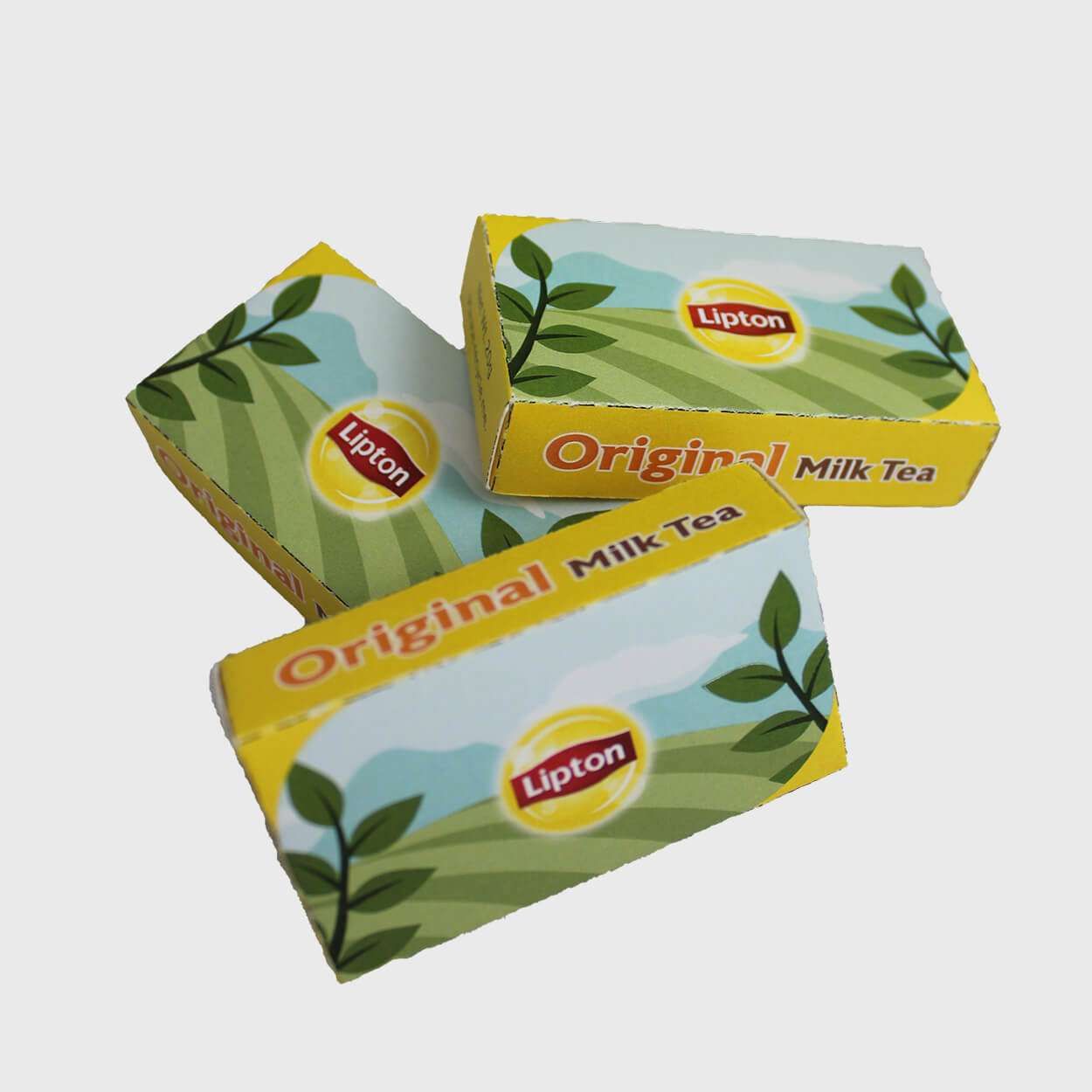 Three Lipton Original Milk Tea packets with yellow and green packaging featuring leaves and a sunny landscape design.