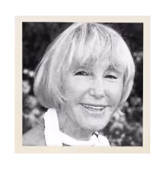 Black and white portrait of an elderly woman with short hair smiling gently.