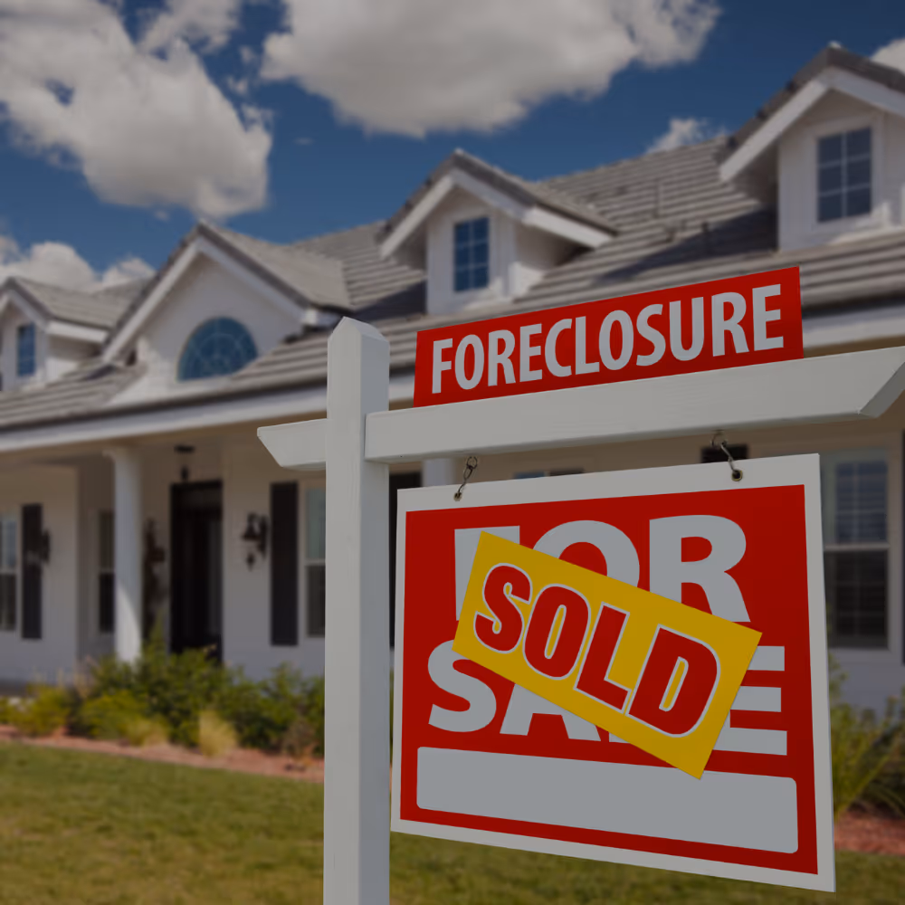 Single-story desert home with warm lights at sunset, featuring gravel yard and desert plants.