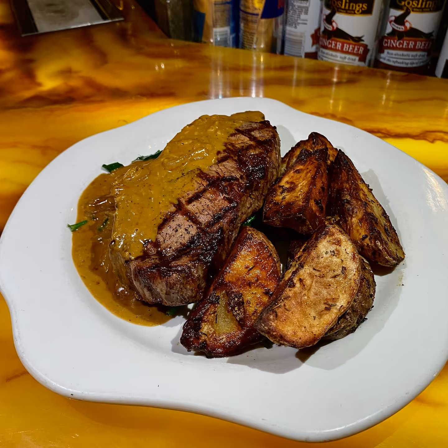 12oz New York Strip with roasted potatoes, spinach, and a whiskey ginger cream sauce.