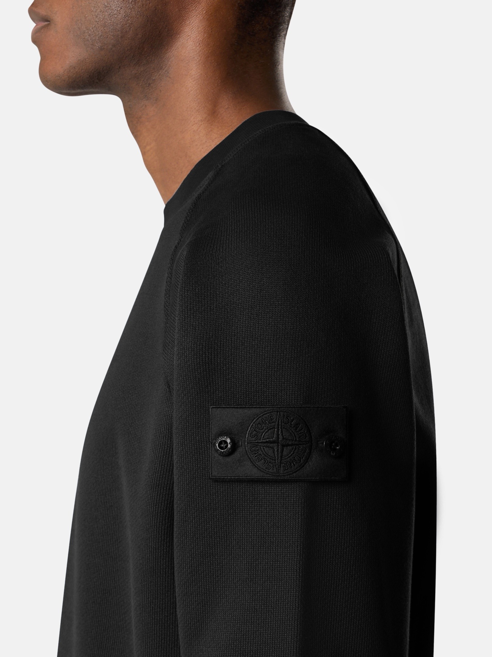 Caption: The badge remained. Only its contrast disappeared. Image Credit: Stone Island Ghost Pieces, monochrome compass badge across brushed cotton, David-TC, knitwear and Alcantara constructions. Courtesy Stone Island.
