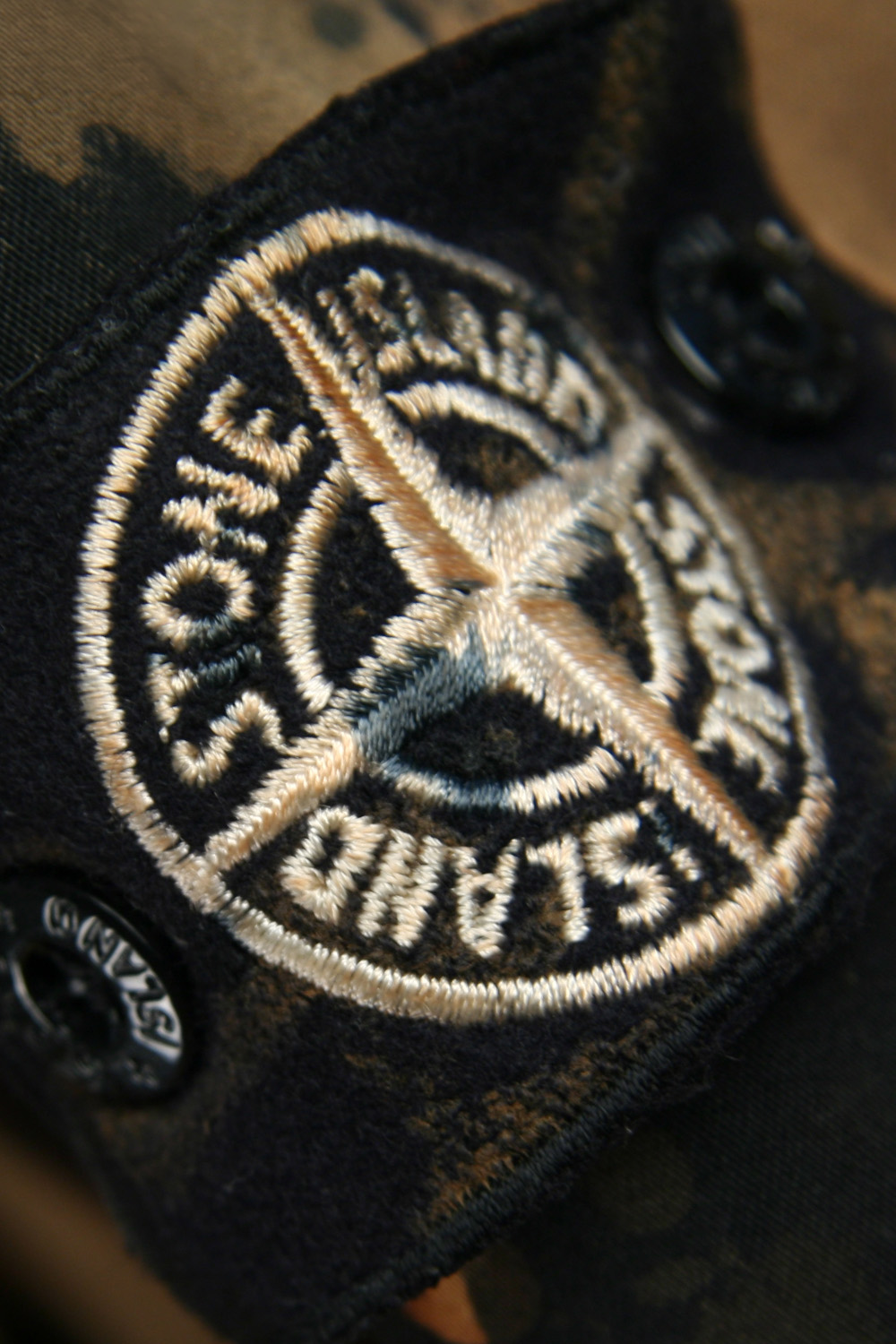 The house mark entered the field instead of standing above it. Image Credit: Stone Island, Hand-Painted Camouflage badge detail, Autumn Winter ’008–’009. Art. 49154C43. Photograph: Found_NYC Archive.