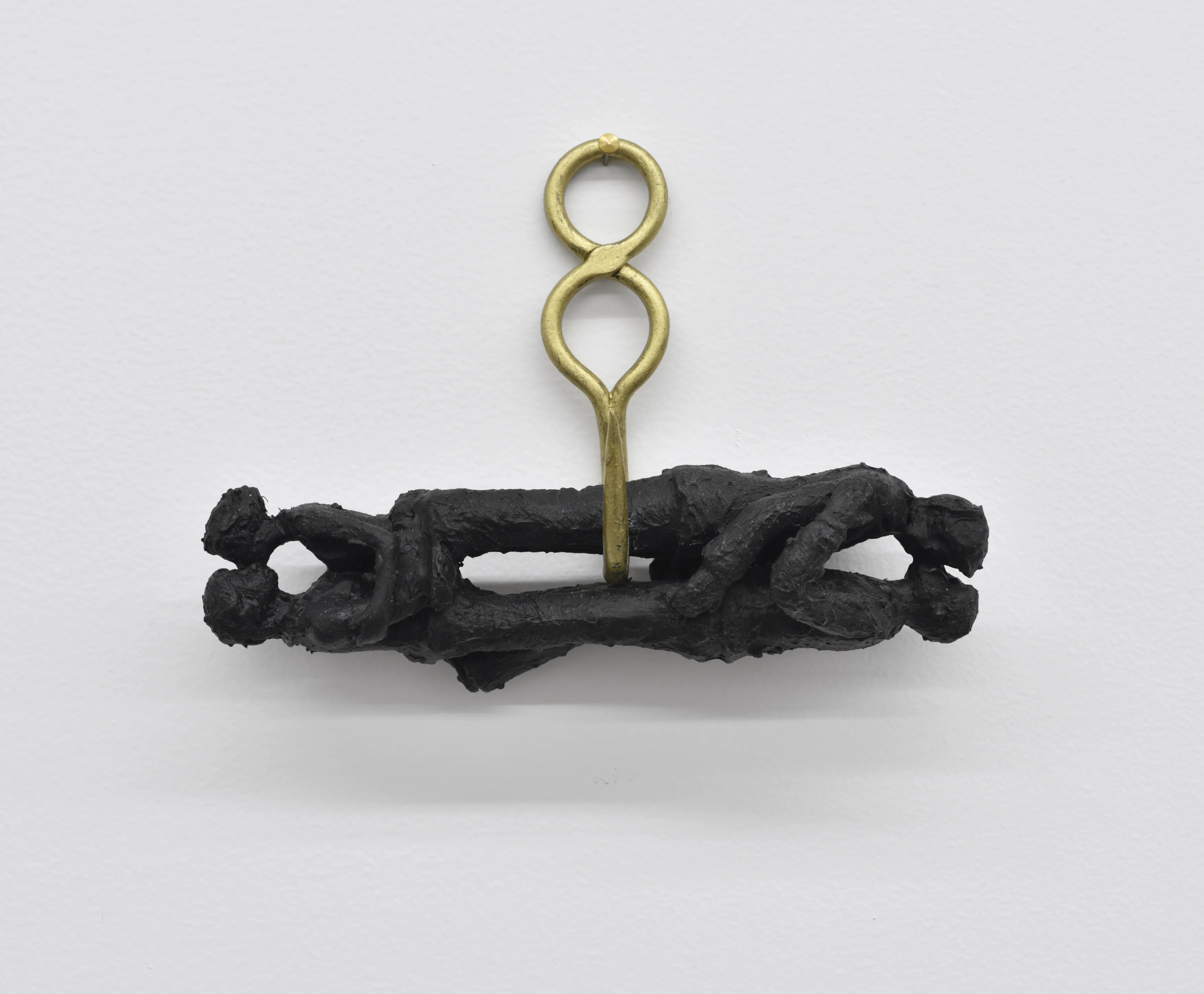 The figures hang together from a single brass hook; their embrace is now held by the hardware. Image Credit: Annette Messager, Les Amoureux, 2016. Photo: Rebecca Fanuele.