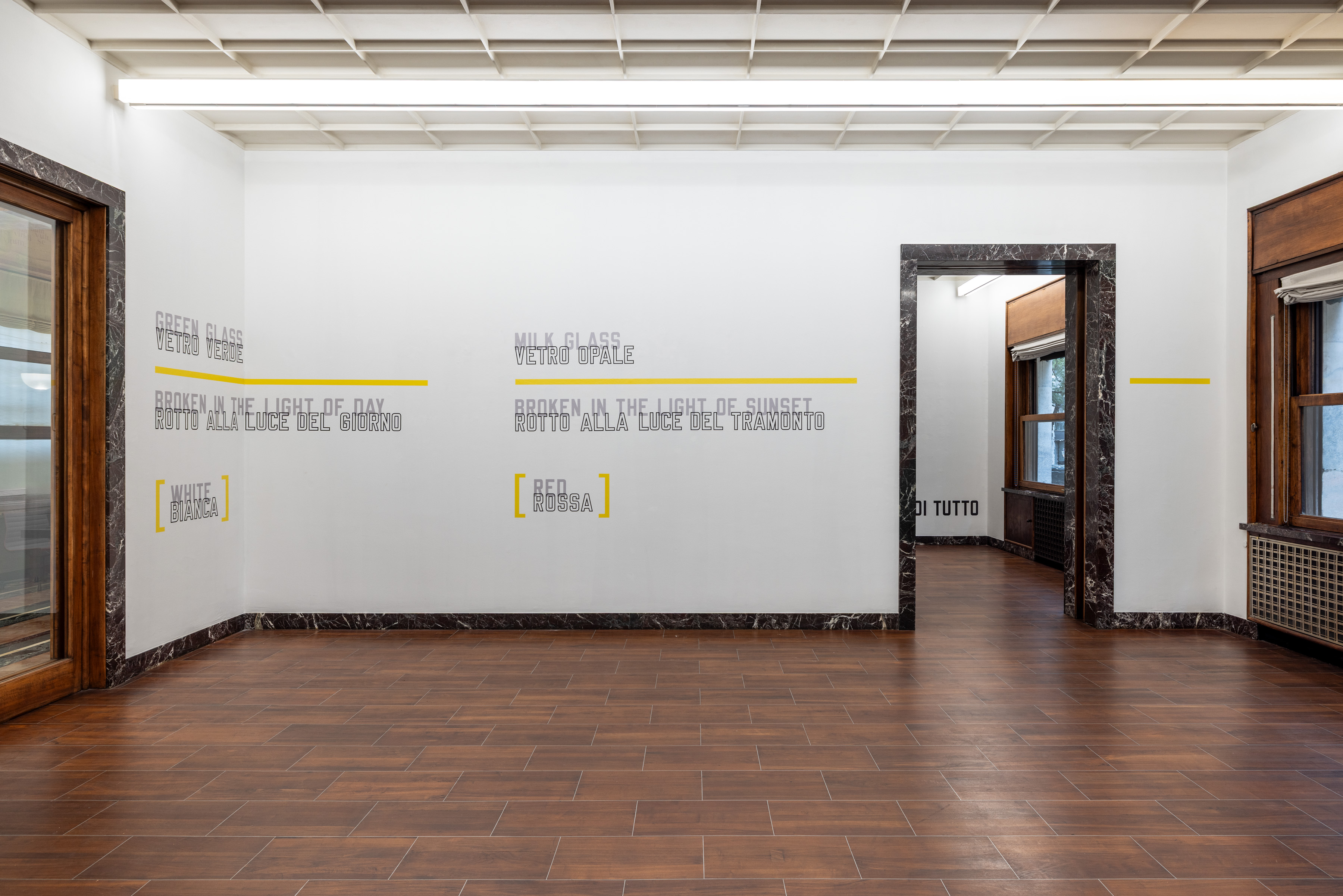 GREEN GLASS and MILK GLASS pair grey language with yellow rules and brackets; the colour named by the words never appears in the words themselves. Image Credit: Installation view. Courtesy of the Artist and MASSIMODECARLO. Photo: Roberto Marossi.