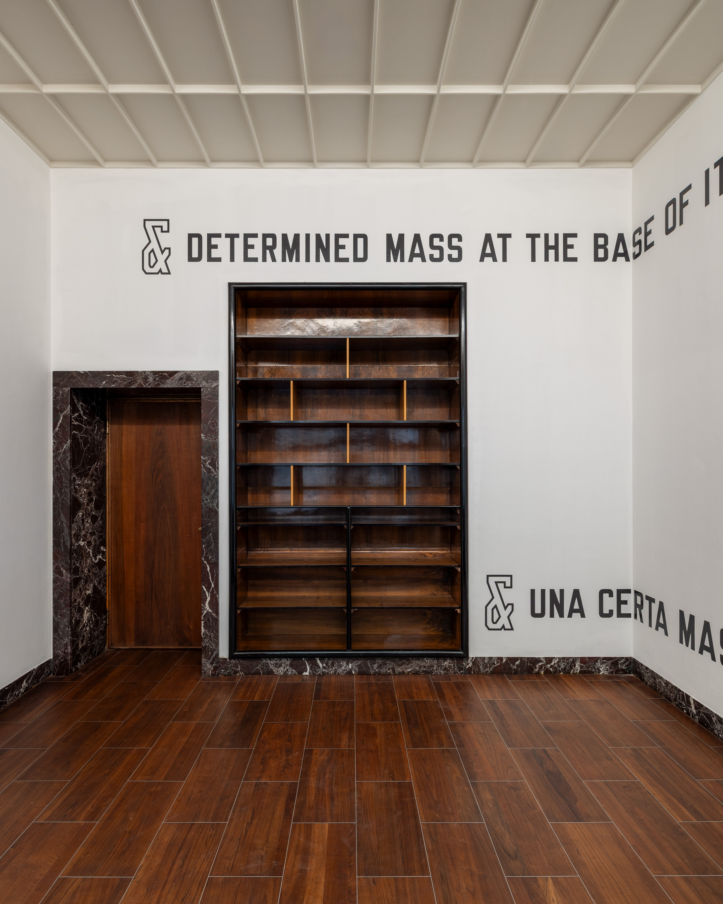 English runs high and Italian low, leaving almost the full height of the wall empty between them; each language begins with an outlined ampersand. Image Credit: Installation view. Courtesy of the Artist and MASSIMODECARLO. Photo: Roberto Marossi.