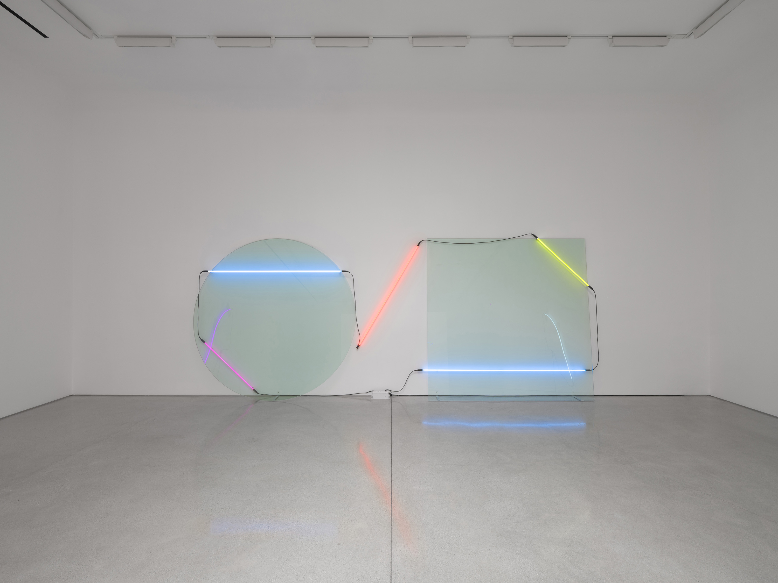 In Ba-O-Ba I five tubes run in one chain across disc, bare wall and square, both ends returning to a small white box on the floor. Image Credit: Installation view. Courtesy Estate of Keith Sonnier and David Kordansky Gallery. Photo: Jeff McLane.