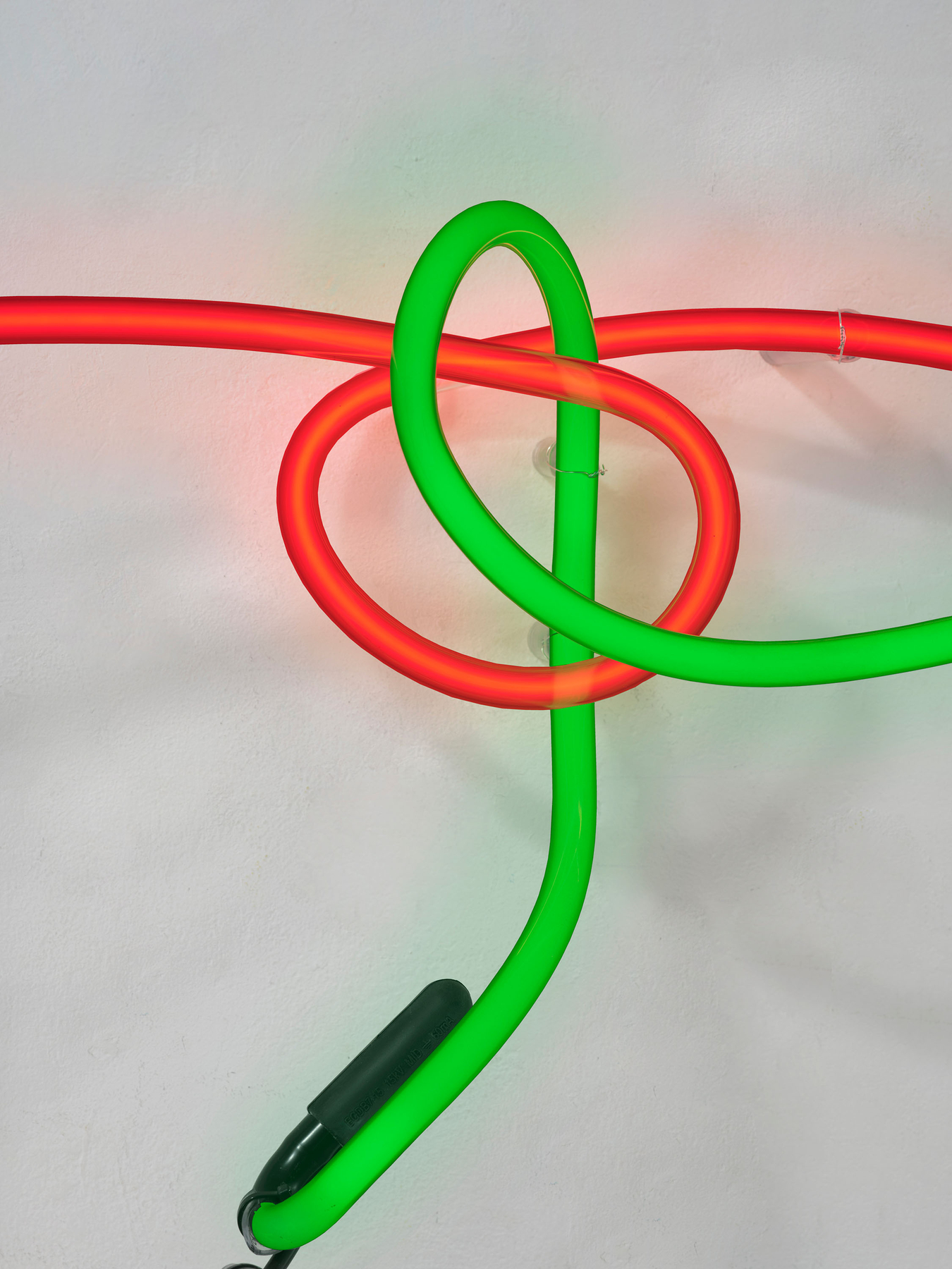 The tubes pass through each other unconnected. At the far left, a slack black jumper runs from one to the other. Image Credit: Neon Wrapping Incandescent V, 1970 (detail). Courtesy Estate of Keith Sonnier and David Kordansky Gallery. Photo: Jeff McLane.