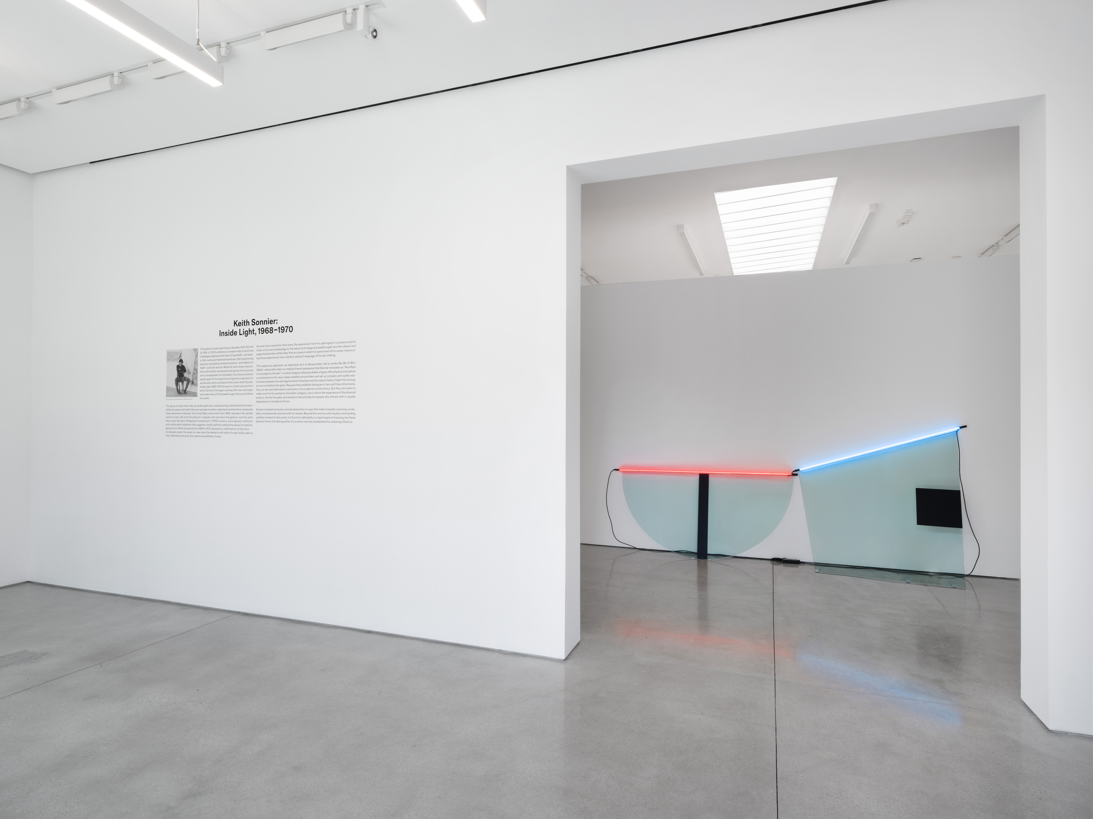 Through the opening in the title wall, Dyad Cut Ba-O-Ba is already complete: two lines of neon over two pieces of glass. Image Credit: Installation view. Courtesy Estate of Keith Sonnier and David Kordansky Gallery. Photo: Jeff McLane.