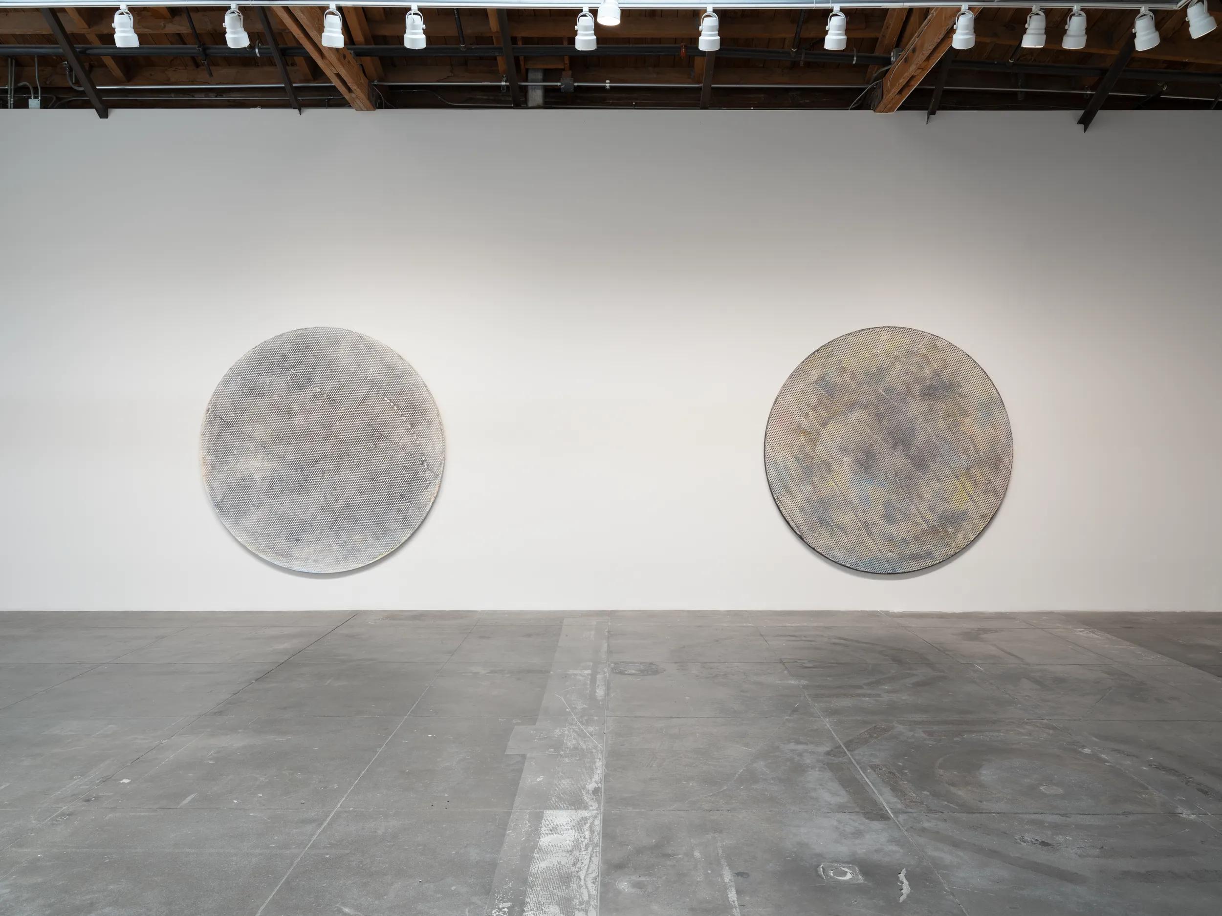 Two discs of one diameter hang as a pair on the hall's longest wall. The one on the right is Sphere. Image Credit: Installation view, Jack Whitten: The Numinous, Hauser & Wirth Downtown Los Angeles, 2026–27. Photo: Roger Edwards.