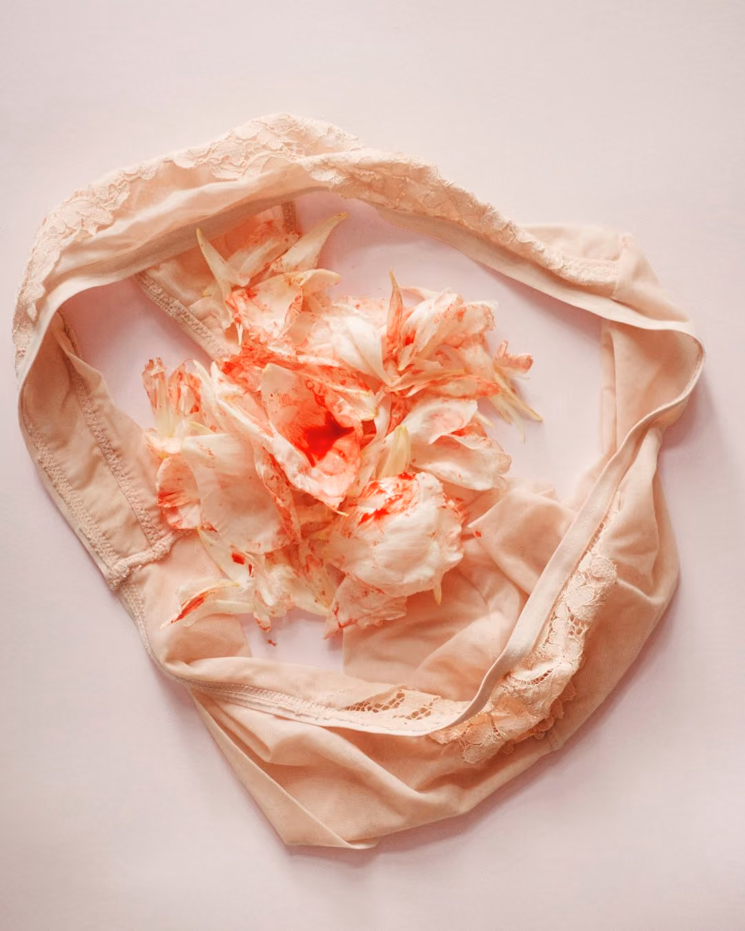 Women's satin underwear with a delicate flower petal streaked with red.