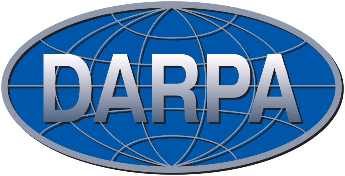 Oval blue badge with gray globe lines and bold metallic letters spelling DARPA.