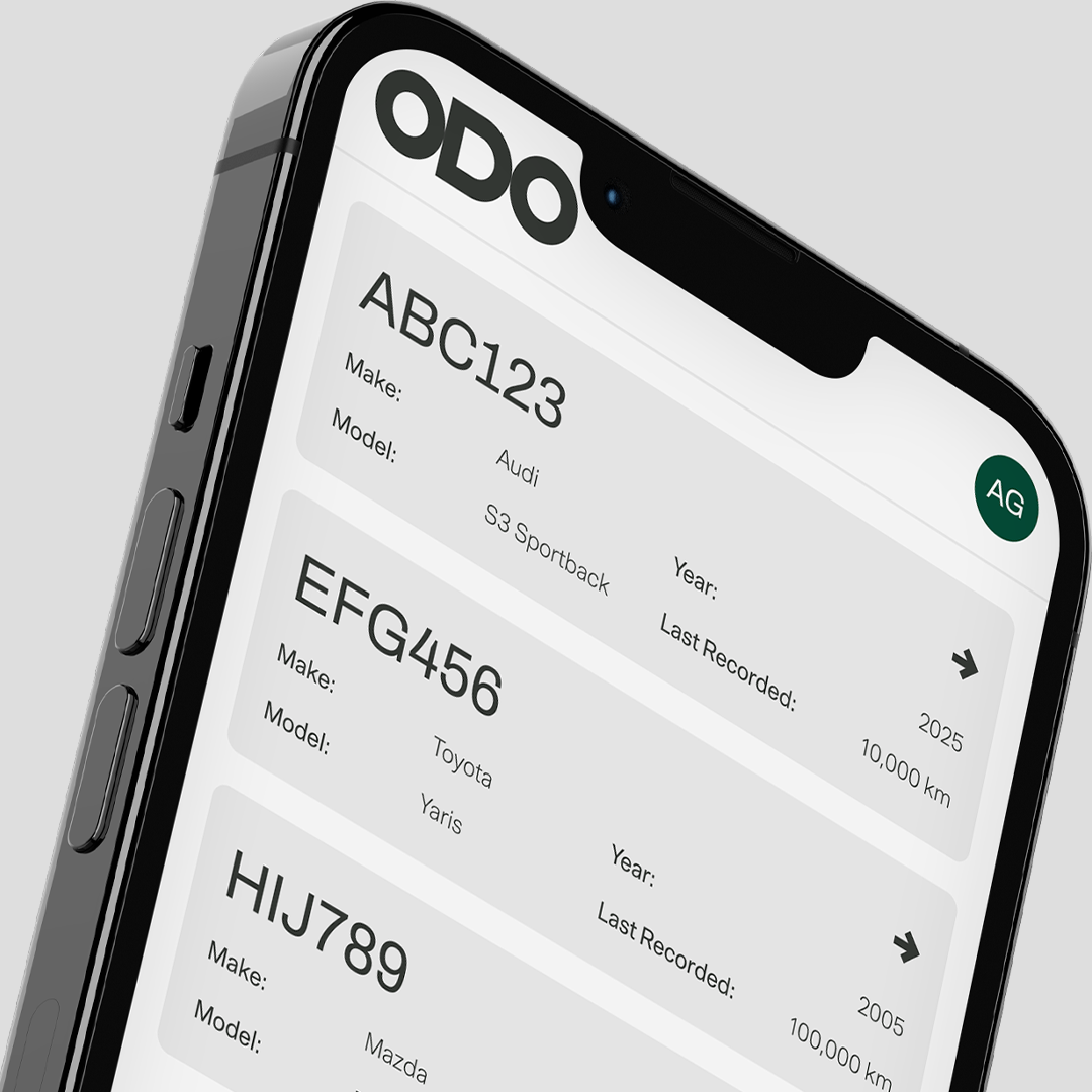 ODO Cars page on an iPhone, showcasing the user’s full vehicle lineup floating over a sleek platinum backdrop.