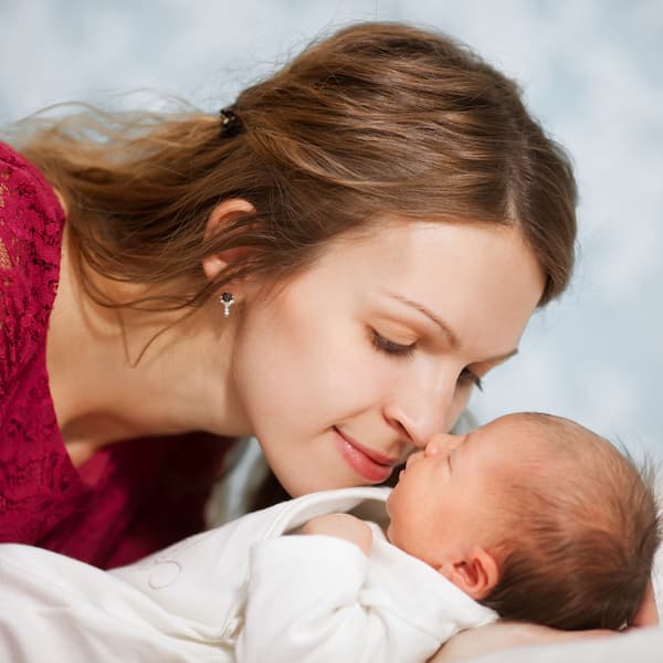 Picture of happy mother with baby in bedroom