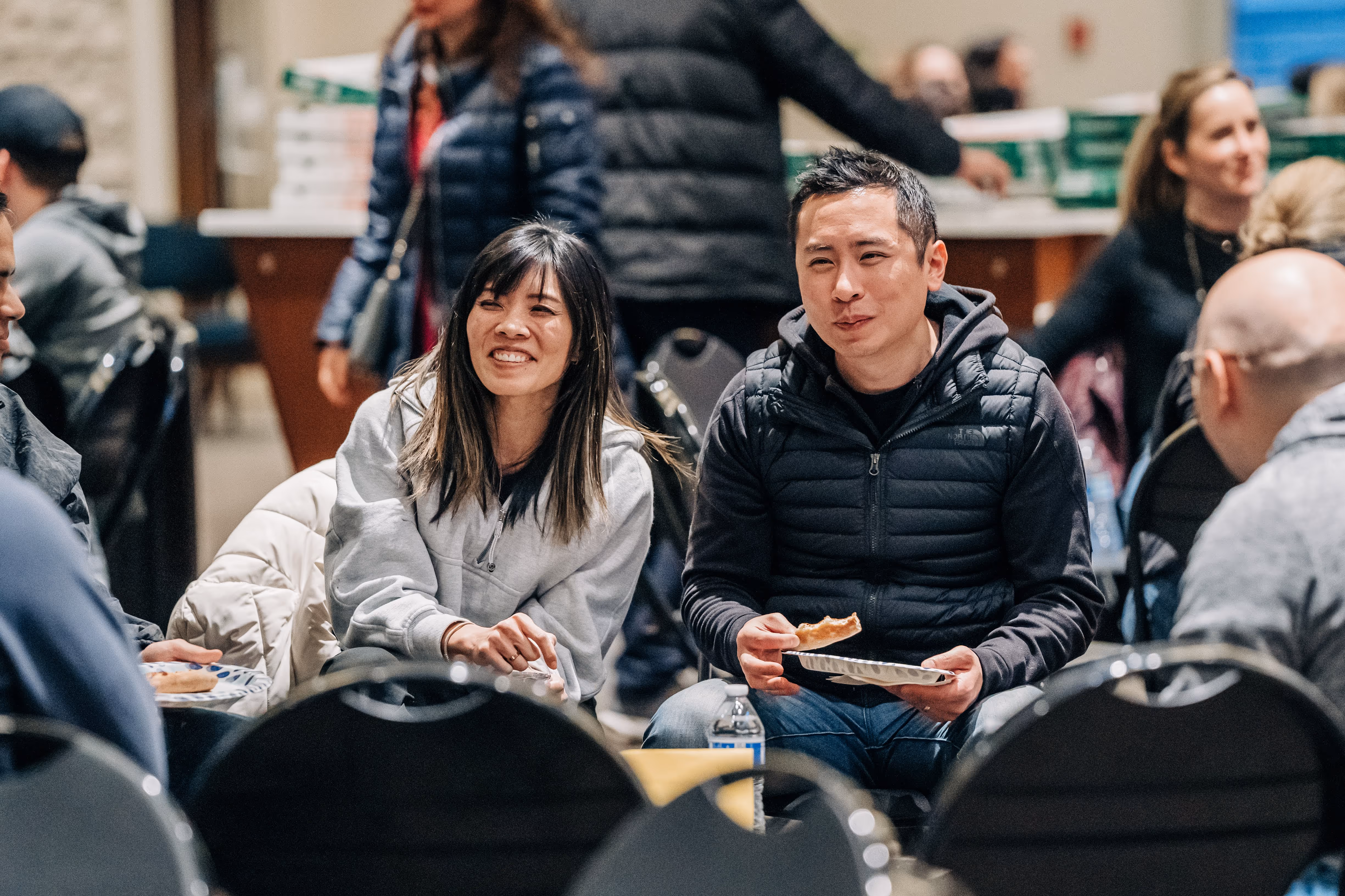 Group of people sitting around and smiling.