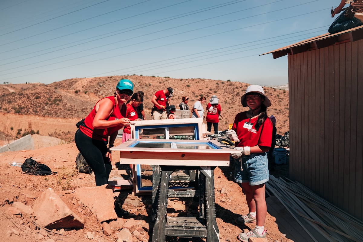 People gathered outside building window panes.