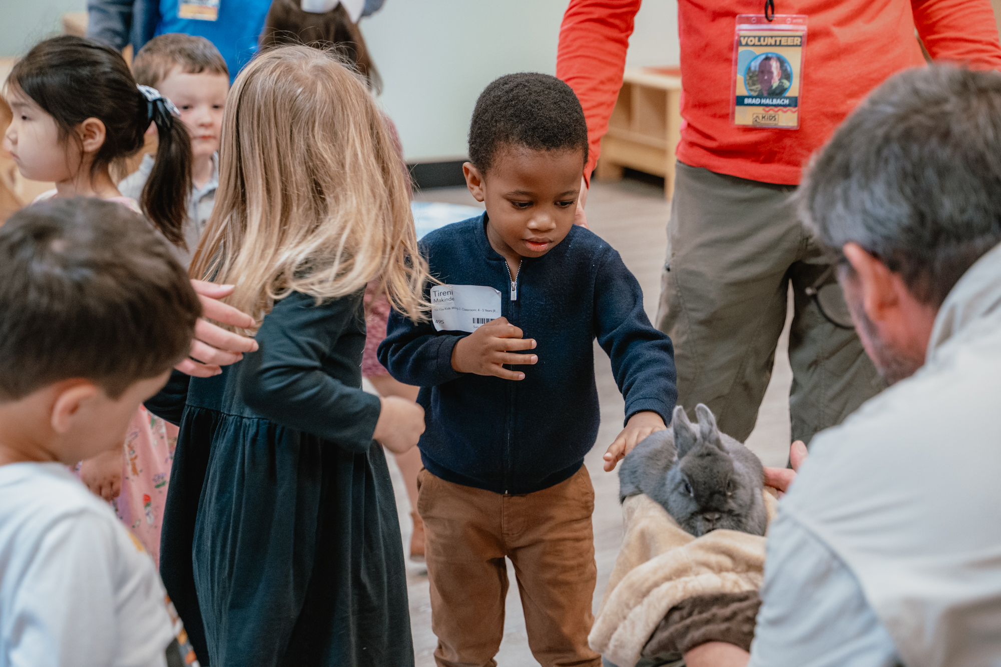 A few kids lined up to pet a bunny.
