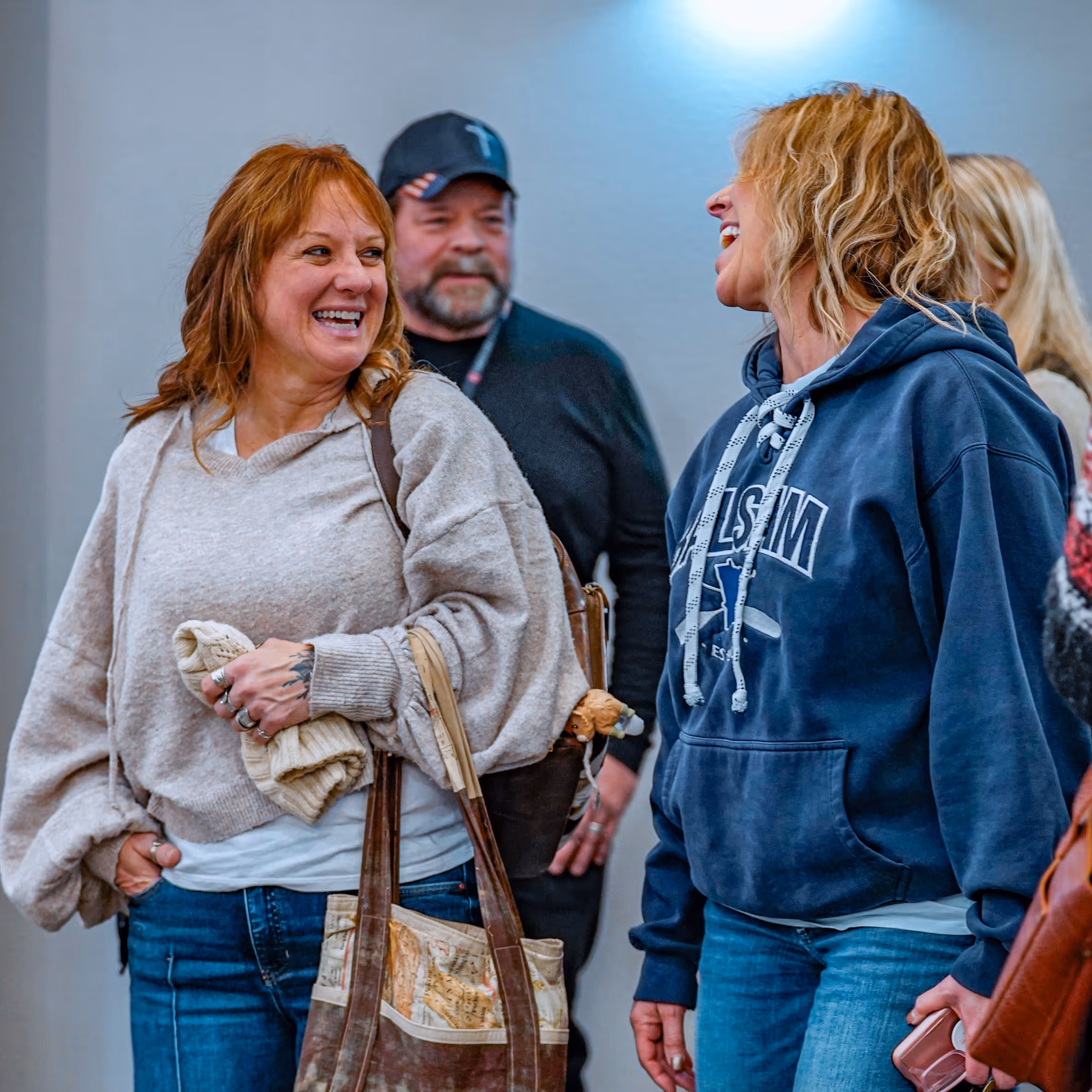 A couple of people standing and laughing together.
