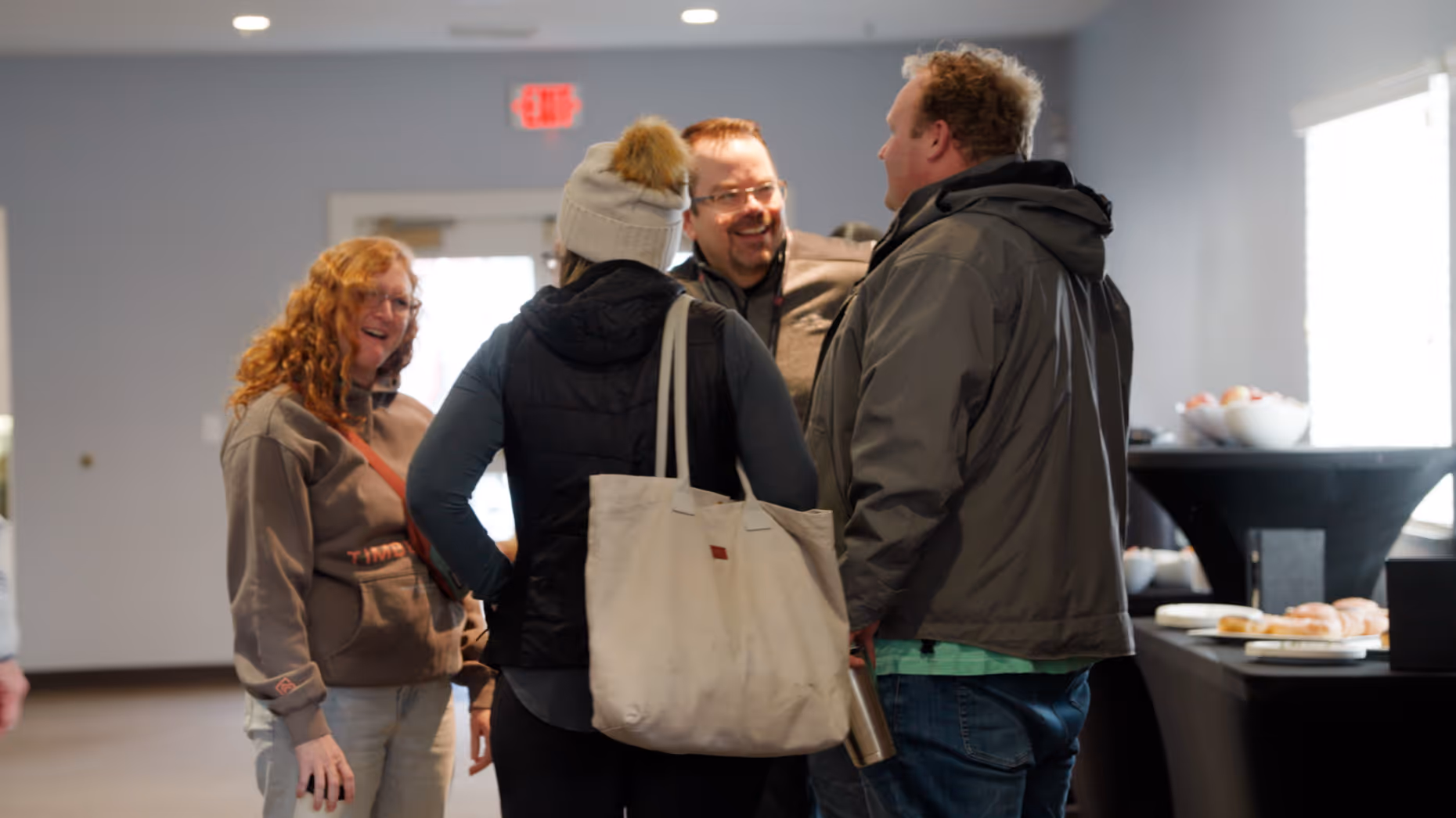 A group of people standing at the lobby talking together.