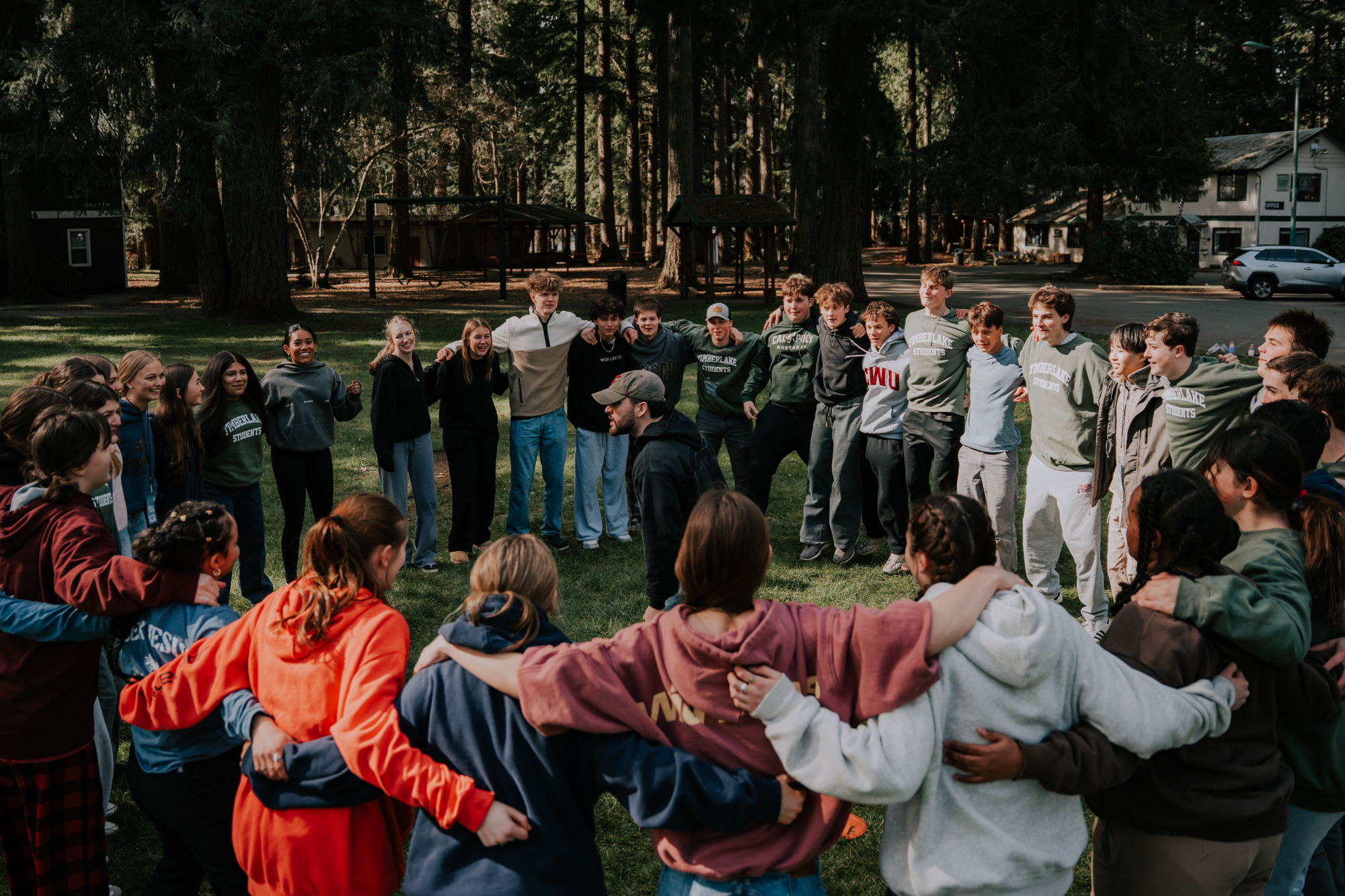 A large group of students huddled together with smiles on their faces.