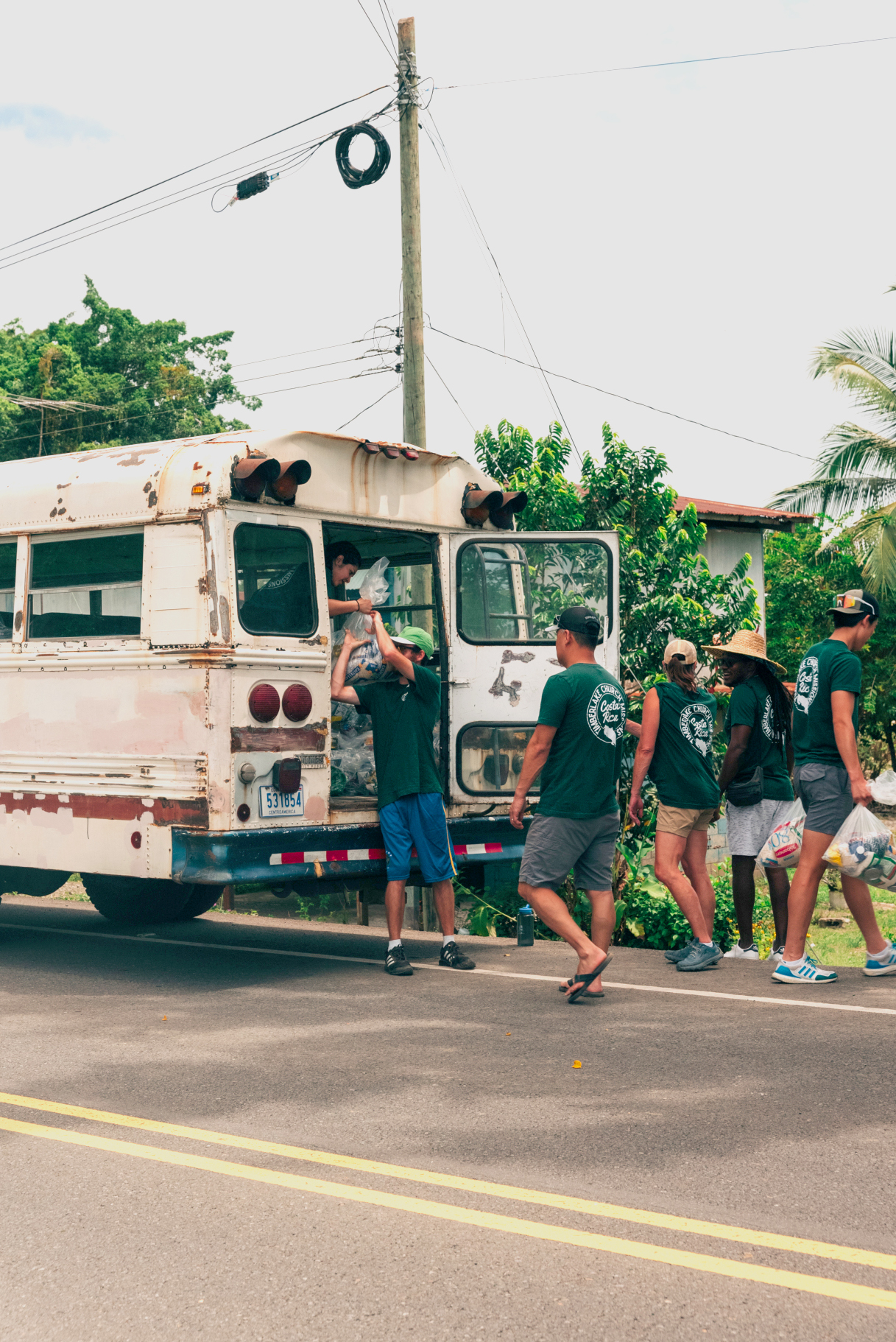 Timberlake missionaries in Costa Rica unloading supplies from a white bus.